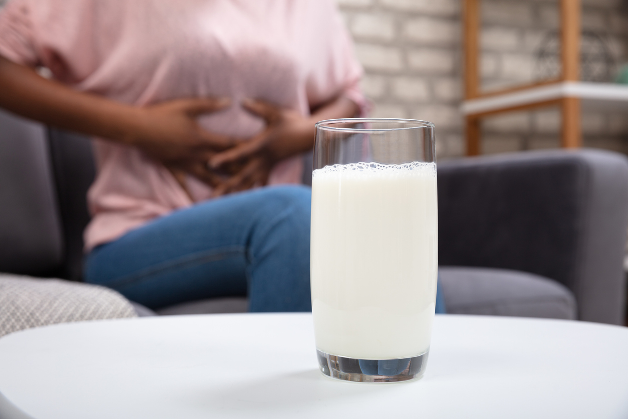 Glass Of Milk In Front Of Woman with Lactose Intolerance