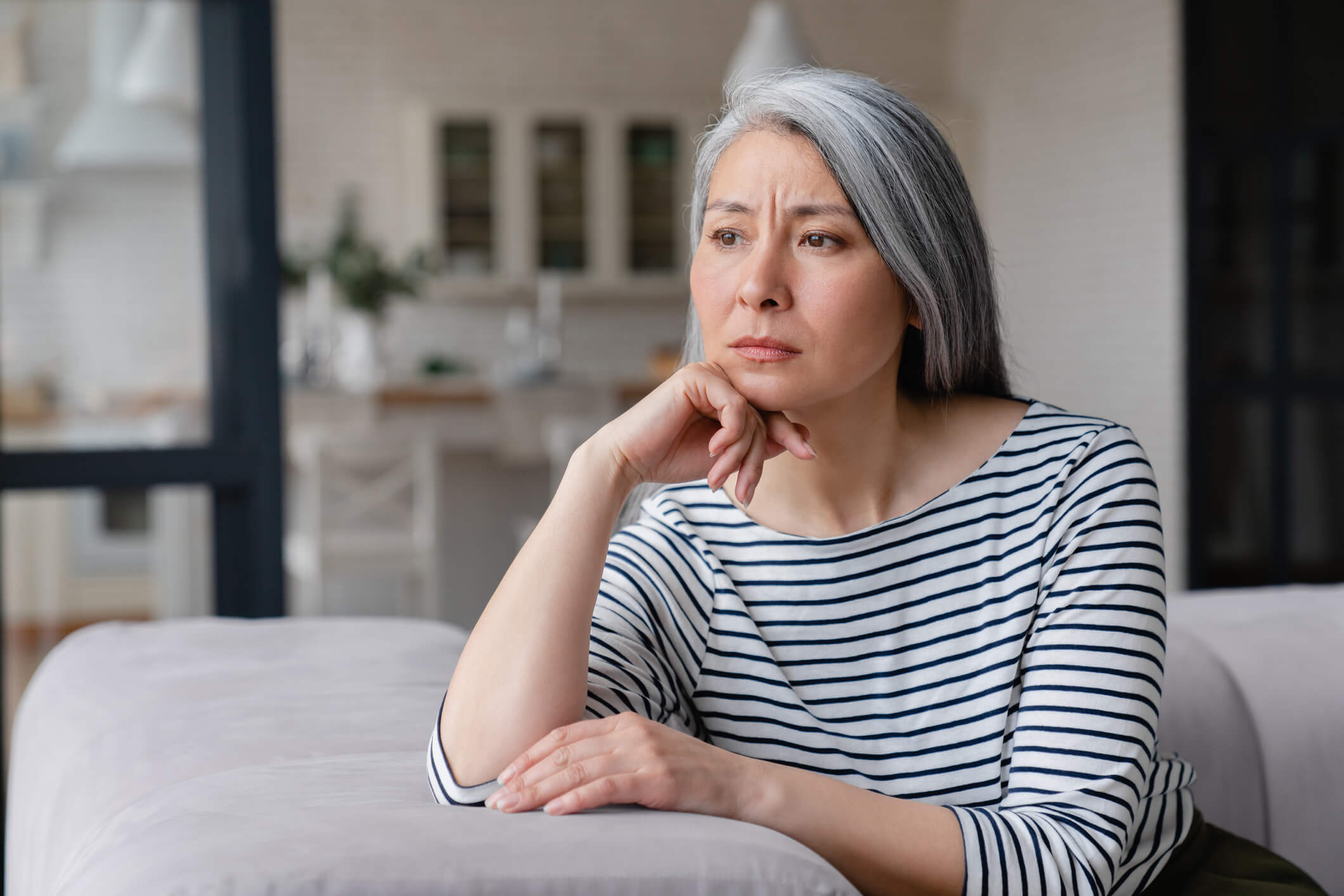 Woman sitting on a couch looking concerned