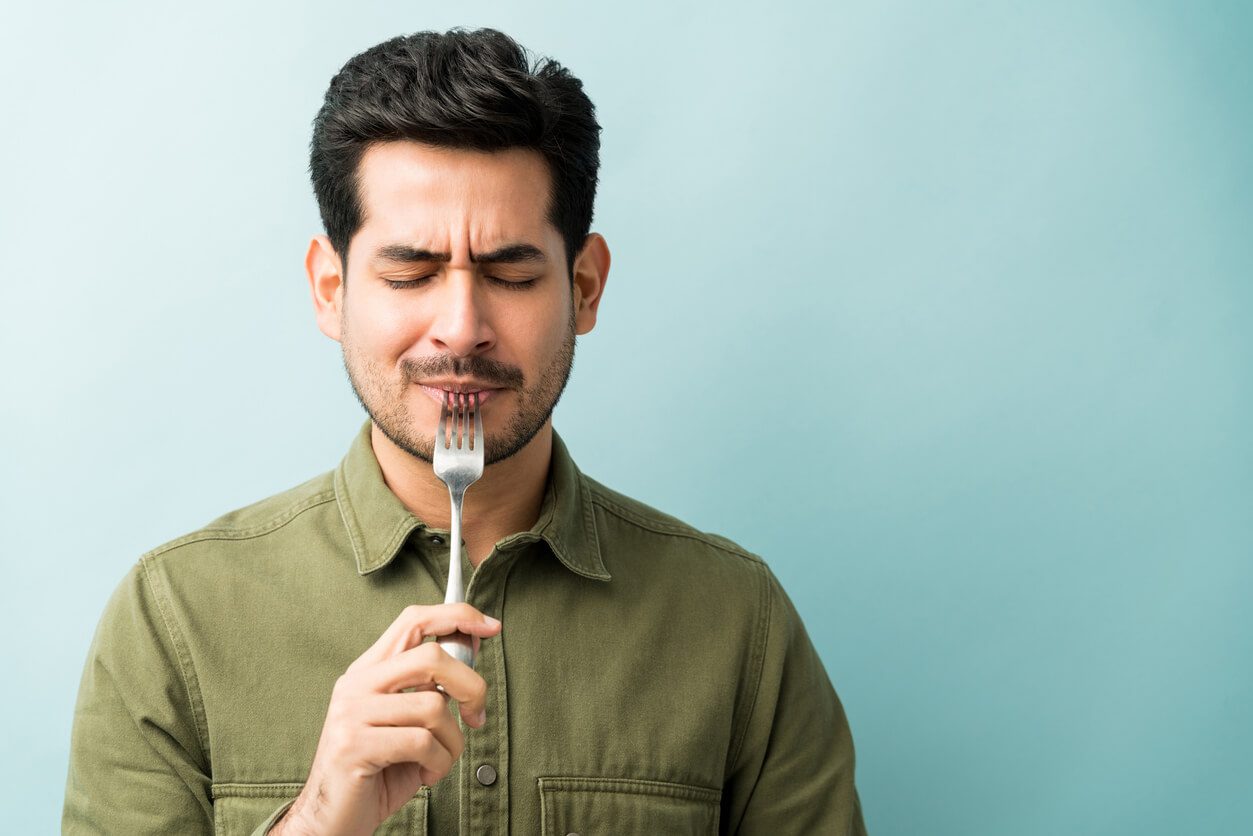 Man with a fork in his mouth